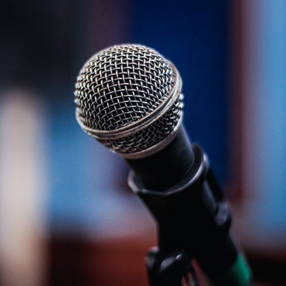 A microphone in front of a blue wall.