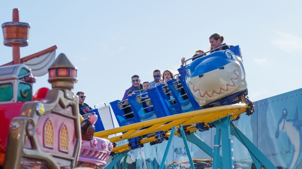 Guests ride a shark-themed roller coaster at Jenkinson’s Boardwalk.